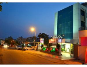 那格浦尔Hotel Flora Inn, Nagpur的夜间有楼房和汽车的城市街道