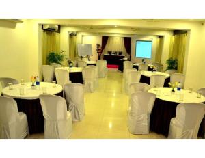那格浦尔Hotel Flora Inn, Nagpur的一间会议室,配有白色的桌子和白色的椅子