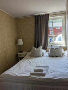 UlvöhamnUlvö Hamnkrog的一间卧室配有带两个枕头的床和窗户
