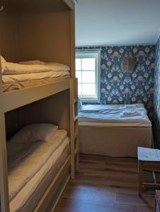 UlvöhamnUlvö Hamnkrog的一间卧室设有两张双层床和一扇窗户。