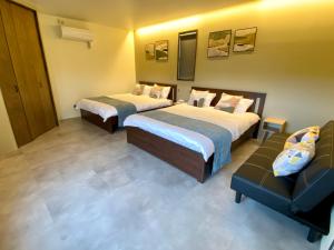 吉马Sky Blue Villa沖縄的酒店客房,设有两张床和一张沙发