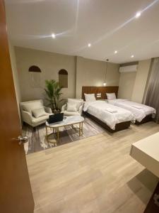 开罗Nakhil Inn Residence的一间卧室配有两张床、一张沙发和一张桌子