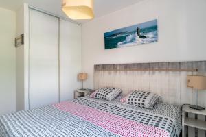 贝诺代Le Kichen - Appt proche de la plage的一间卧室配有一张带两个枕头的床