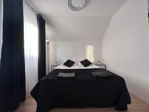 德兹维济诺NT Holiday的一间卧室配有一张黑色的床和墙上的时钟