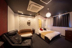 大阪noah grande的一间卧室配有一张床、一张沙发和一把椅子