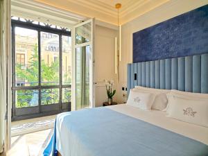 格拉纳达Palacio Gran Vía, a Royal Hideaway Hotel的一间卧室设有一张大床和一个大窗户