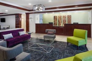 萨凡纳普勒萨凡纳机场拉昆塔旅馆及套房的大堂设有配备紫色和绿色椅子的等候室