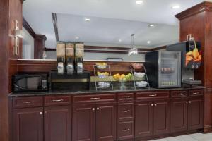萨凡纳普勒萨凡纳机场拉昆塔旅馆及套房的厨房配有棕色橱柜和水果台