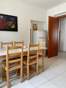 CorazzelloVilla Claudia - appartamento A的厨房配有桌椅和冰箱。