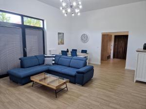 达洛科Apartamenty Przy Latarni Kropla Bałtyku的客厅配有蓝色的沙发和桌子