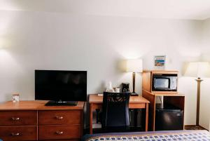 WorlandTravelodge by Wyndham Worland的酒店客房配有一张床和一张书桌及一台电视