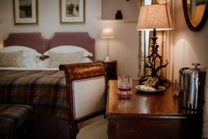 多诺赫Links House at Royal Dornoch的一间卧室配有一张床和一张带台灯的书桌