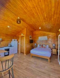 Malin HeadCosy Portmor Log Cabin的一间卧室设有一张床和木制天花板