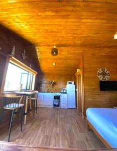 Malin HeadCosy Portmor Log Cabin的客房设有厨房、桌子和椅子。
