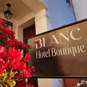 萨尔塔Blanc Hotel Boutique的红花酒店大楼前的标志