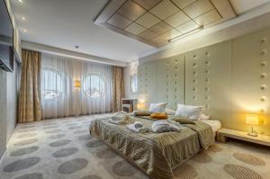 克拉科夫秋千酒店的一间卧室配有一张大床和毛巾