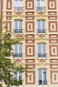 勒阿弗尔Smart Appart Le Havre 97的一座高高的砖砌建筑,设有窗户和阳台