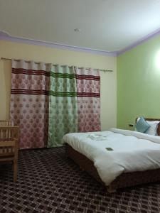 洪达尔Maryoul Guest House, Hunder Nubra的一间卧室设有两张床和窗户。
