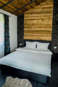 瓦特拉多尔内Tiny House Todireni的卧室配有白色的床和木墙