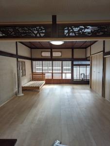 福知山ひろの家的一间设有木地板和窗户的大客房