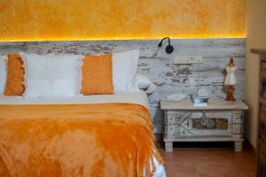 帕拉莫斯Hotel Sant Joan的一间卧室配有一张带橙色毯子和桌子的床
