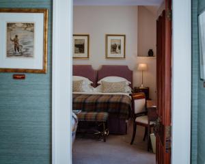 多诺赫Links House at Royal Dornoch的卧室配有一张床和一张桌子及椅子