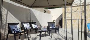 班吉Apartments Villa Mihaela的庭院配有三把椅子、一张桌子和一把遮阳伞