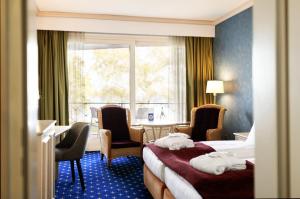 马兰迪Hotel Dieksee - Collection by Ligula的酒店客房带两张床和一张桌子以及椅子。