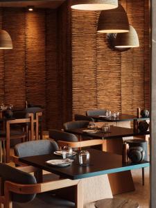 伊亚Hom Santorini的一间在房间内配有桌椅的餐厅