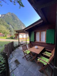 特里森Campingplatz Mittagsspitze的房屋内带木桌和椅子的庭院