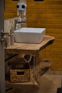 百乐·奥拉内斯蒂Cabana A frame Olanesti的浴室内木制柜台上的白色水槽