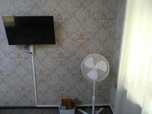 巴库cozy home的客房设有风扇和墙上的电视。