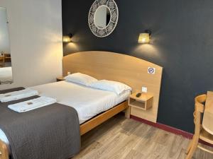 瓦朗斯里昂酒店的卧室配有一张床,墙上设有镜子