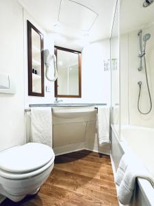 瓦朗斯里昂酒店的白色的浴室设有卫生间和水槽。