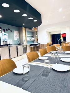瓦朗斯里昂酒店的餐厅配有长桌、椅子和盘子