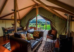 Shelsley WalshHakuna Matata Safari Lodge - Sublime, off-grid digital detox with hot tub的带沙发和帐篷的客厅