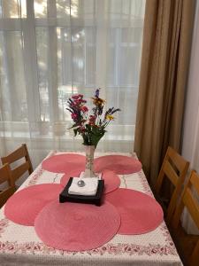 布达佩斯Family Home的一张红色的桌子,上面有花瓶