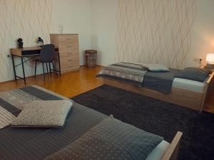 马里博尔Apartmaji Sofia的配有书桌和书桌的客房内的两张床