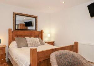 Upper HulmePine cottage with private hot tub的一间卧室配有一张带镜子和椅子的床