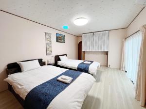 金泽Kanazawa Seiren Le Lotus Bleu的两张位于酒店客房的床,配有毛巾