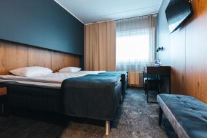 塔林歇奈里GO酒店的一间卧室设有两张床、一张桌子和一个窗口。