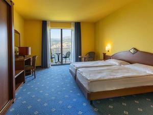 马尔切西内Natur Resort Panorama的酒店客房设有一张床和一个阳台。