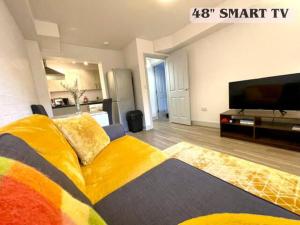 彼索普斯托福Bright & Cosy One Bedroom Apartment - Perfect base in Bishop's Stortford的客厅配有黄色沙发和平面电视。