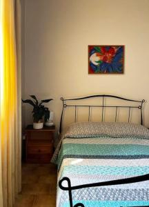加夫里翁Andros escape - a cosy 1bed flat的卧室配有一张床,墙上挂有绘画作品