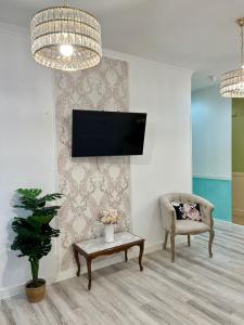 马德里米兰旅舍的客厅配有沙发和墙上的电视