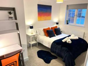彼索普斯托福Bright & Cosy One Bedroom Apartment - Perfect base in Bishop's Stortford的一间卧室配有一张带橙色和蓝色枕头的大床