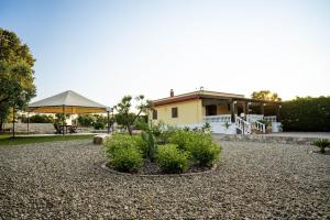 莫托拉Villa Patrizia-Luxury Villa的一座房子,上面有大伞和一些植物