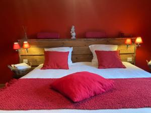 拉布雷斯切兹让米翁旅馆的一间卧室配有一张带两个红色枕头的床