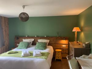 拉布雷斯切兹让米翁旅馆的一间卧室设有一张带绿色墙壁的大床