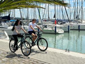 巴拉顿凯奈谢码头酒店的一名男子和女子骑着自行车在码头附近